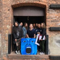 Students outside the Anderson Arts building with artwork